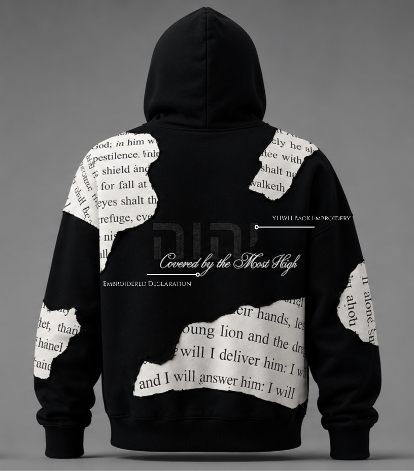 Back view of The Covering Hoodie by Ordained 
Origins. Black oversized French terry cotton 
hoodie featuring torn scripture panel patches 
of Psalm 91 KJV text in black serif font on 
cream white fabric, physically sewn across the 
back body and sleeves. Centered on the back 
panel is a large tone-on-tone YHWH embroidery 
in Hebrew characters with white cursive script 
reading "Covered by the Most High" beneath it. 
Callout labels identify the YHWH back embroidery 
and embroidered declaration. Grey studio 
