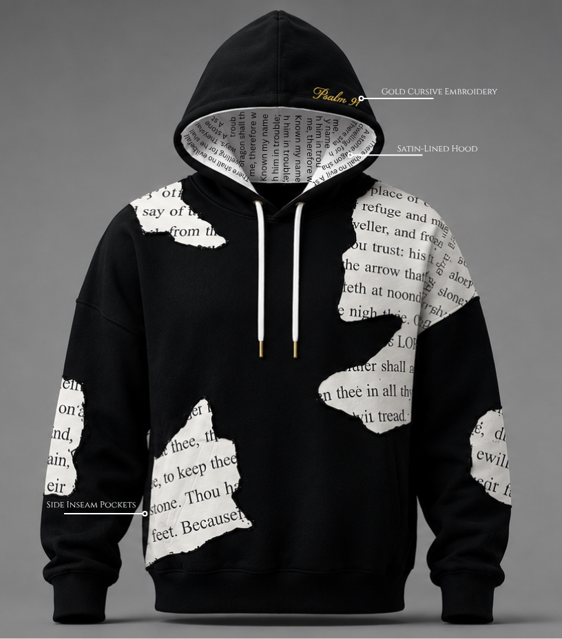 Front view of The Covering Hoodie by Ordained 
Origins. Black oversized French terry cotton 
hoodie featuring torn scripture panel patches 
of Psalm 91 KJV text in black serif font on 
cream white fabric, physically sewn across the 
front body and sleeves. Hood is pulled forward 
revealing a satin cream interior lining with 
full Psalm 91 scripture text printed throughout. 
Gold cursive "Psalm 91" embroidery visible on 
the hood exterior. White drawstrings with gold 
metal tips. Callout labels identify the 