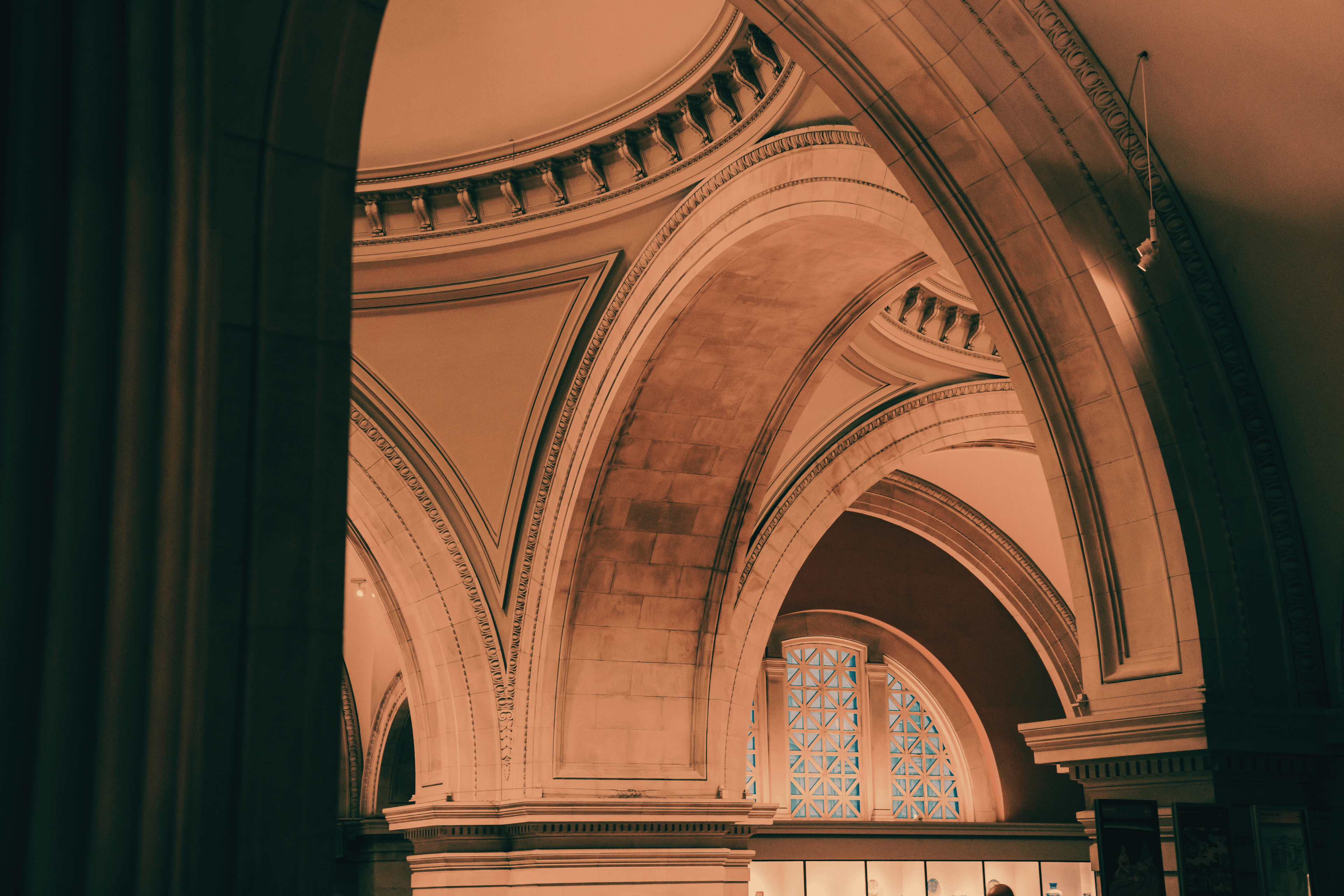 Architectural detail of a building with stone walls and a stained glass window.