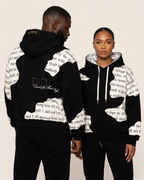 Two people wearing black hoodies with white text design on a beige background